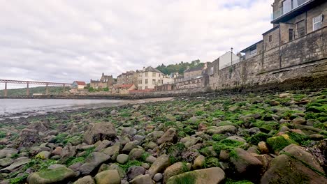 moss-covered rocks along a coastal town