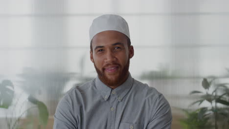 portrait young muslim businessman smiling arms crossed enjoying professional career success mixed race entrepreneur wearing kufi hat in office