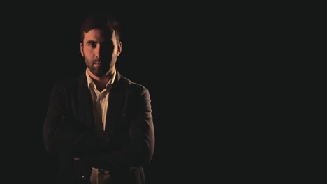 video en 4k de un hombre con traje negro sobre un fondo negro.