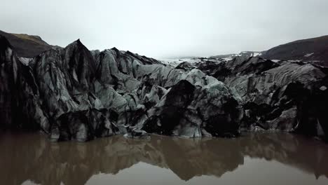aerial view of sólheimajökull glacier, melting into water, in summer, iceland