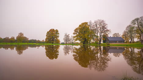 Zeitraffer-Eines-Spiegelnden-Sees-Und-Herbstfarben,-Die-Sich-In-Winterliches-Eis-Und-Schnee-Verwandeln