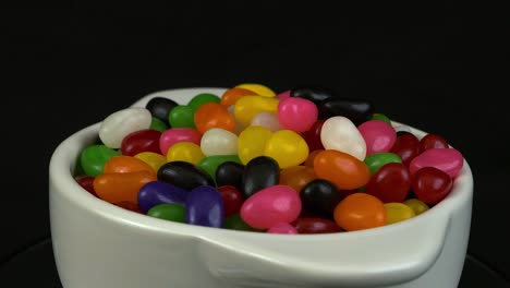 white bowl of colorful jelly beans rotates on black background