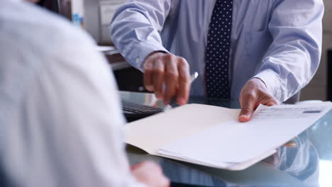 hombre de negocios con un cliente masculino firmando papeles en la oficina