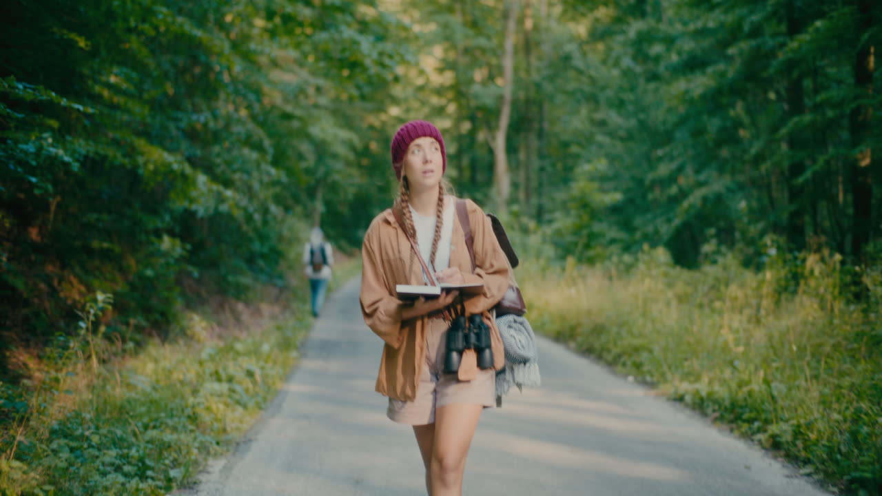 Escursionista donna con libro che esplora la foresta durante le vacanze