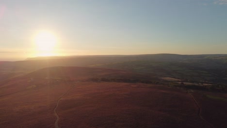 Hermoso-Zumbido-Aéreo-Del-Amanecer-De-Páramos-Con-Brezo-Púrpura-Destello-De-Sol-Temprano-En-La-Mañana-Y-Niebla-En-La-Distancia-4k