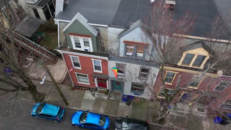 gay pride flag waving outside of city row house in america