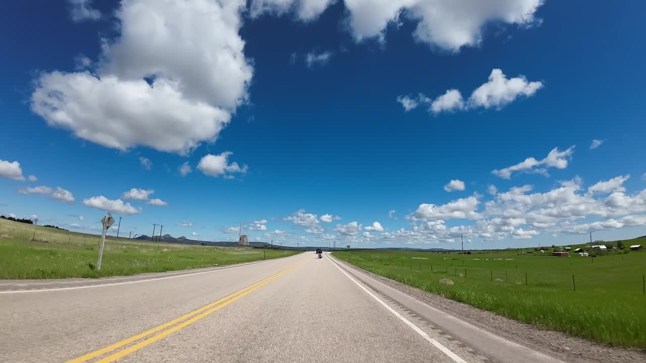 Devils Tower up in the distance approaching on a motorcycle