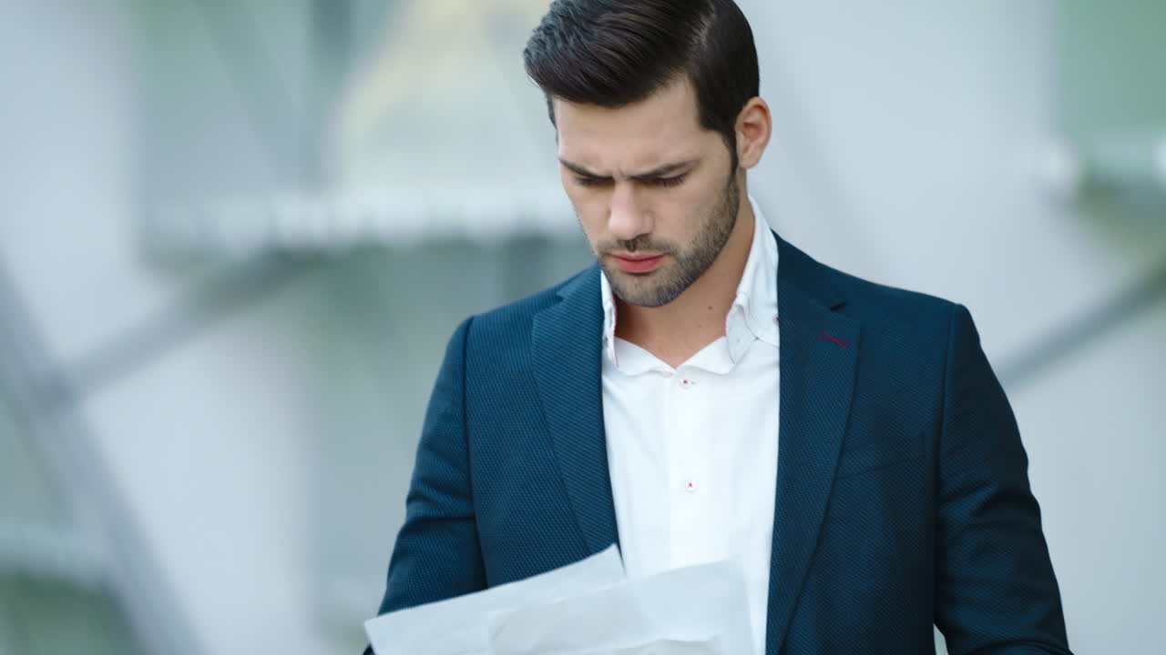 Portrait businessman looking at documents. Man standing with documents outdoors