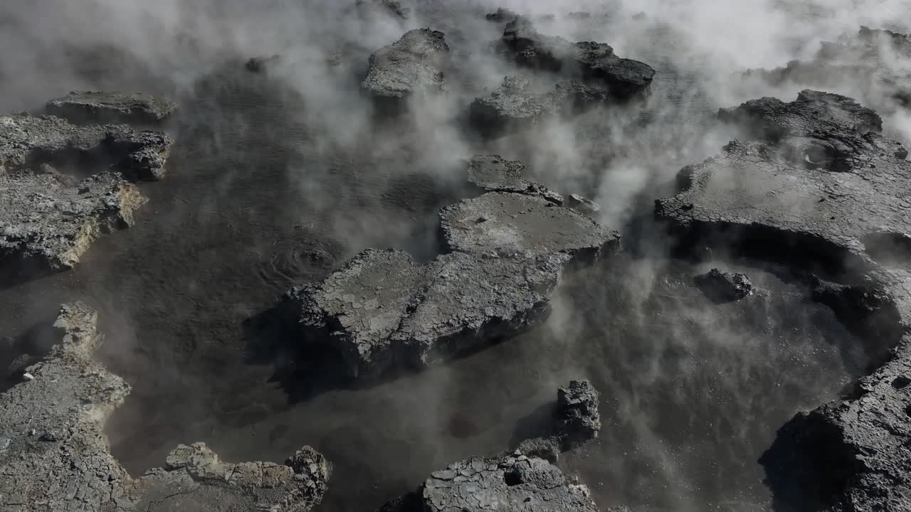 Steamy extreme mud pools, Drone slowly flying over geothermal landscape. Trees, steam, bubbling mud and steam. Alien Landscape. Sci-fi. Global Warming