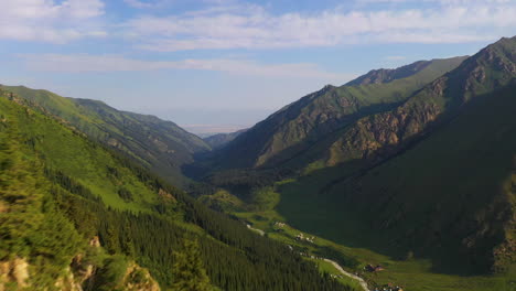 aerial view flying over a ridge to reveal a picturesque mountain valley in kyrgyzstan