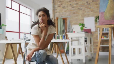 video de una feliz artista femenina biracial sonriendo a la cámara en el estudio