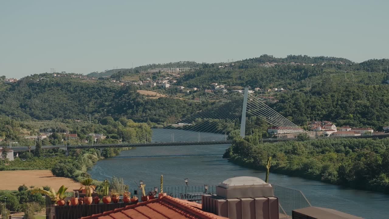 Il Ponte Pedro e Inês attraversa il fiume Mondego a Coimbra, circondato da colline lussureggianti.