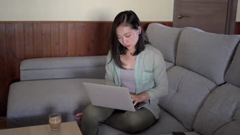 Asian-woman-with-latte-touching-screen-on-smartphone