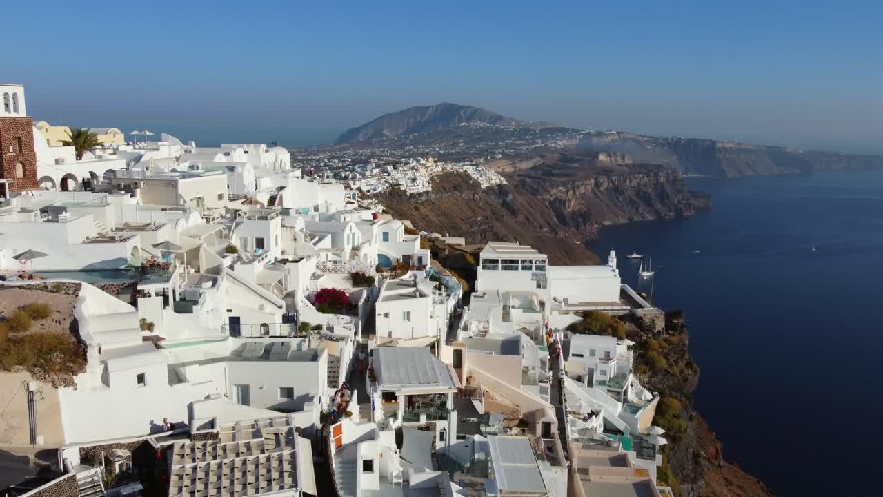 casas y hoteles en el acantilado de la aldea de oia en santorini, grecia, vista aérea cinematográfica