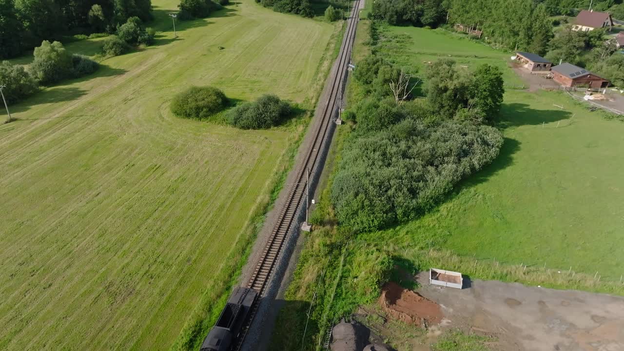 Aerial view of a train passing through a green rural landscape