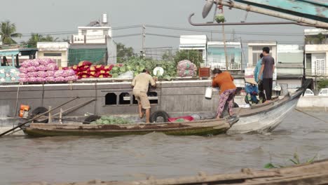 food vendors working on boat in cai rang floating market, vietnam.