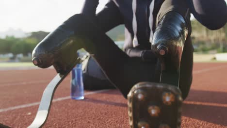 Disabled-mixed-race-man-with-prosthetic-legs-sitting-on-a-race-track