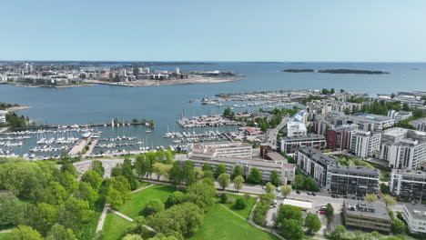 bird flying over the lauttasaari marina, in summer day in helsinki - drone shot