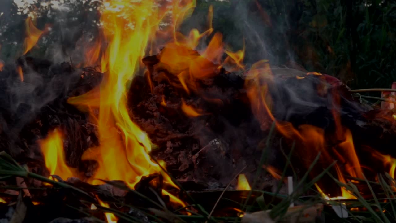 llama de cámara lenta fuego y smog está quemando basura o residuos en fondo oscuro