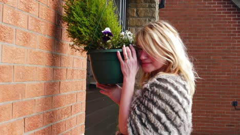 Attractive-woman-enjoying-basket-of-flowers-in-garden-medium-4k-medium-shot-slow-motion-portrait