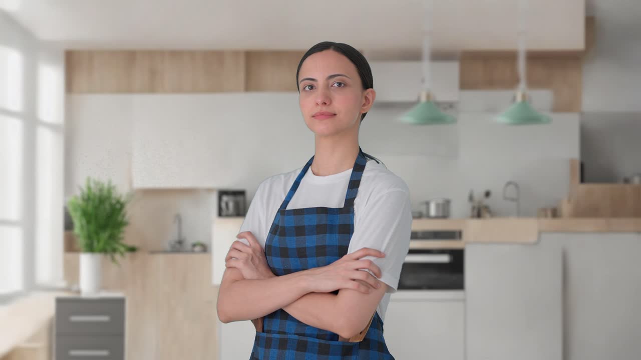 retrato de una ama de casa india de pie con las manos cruzadas