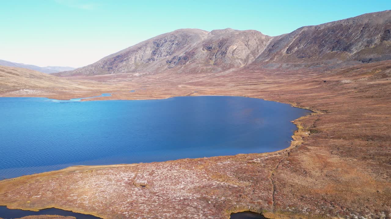Flyover northern lake in beautiful golden arctic tundra in Greenland