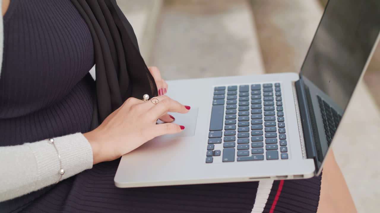 primer plano de una mujer escribiendo en una computadora portátil afuera en cámara lenta