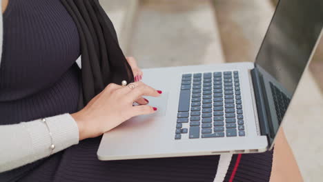 Close-Up-Shot-Of-A-Woman-Typing-On-A-Laptop-Outside-In-Slowmotion