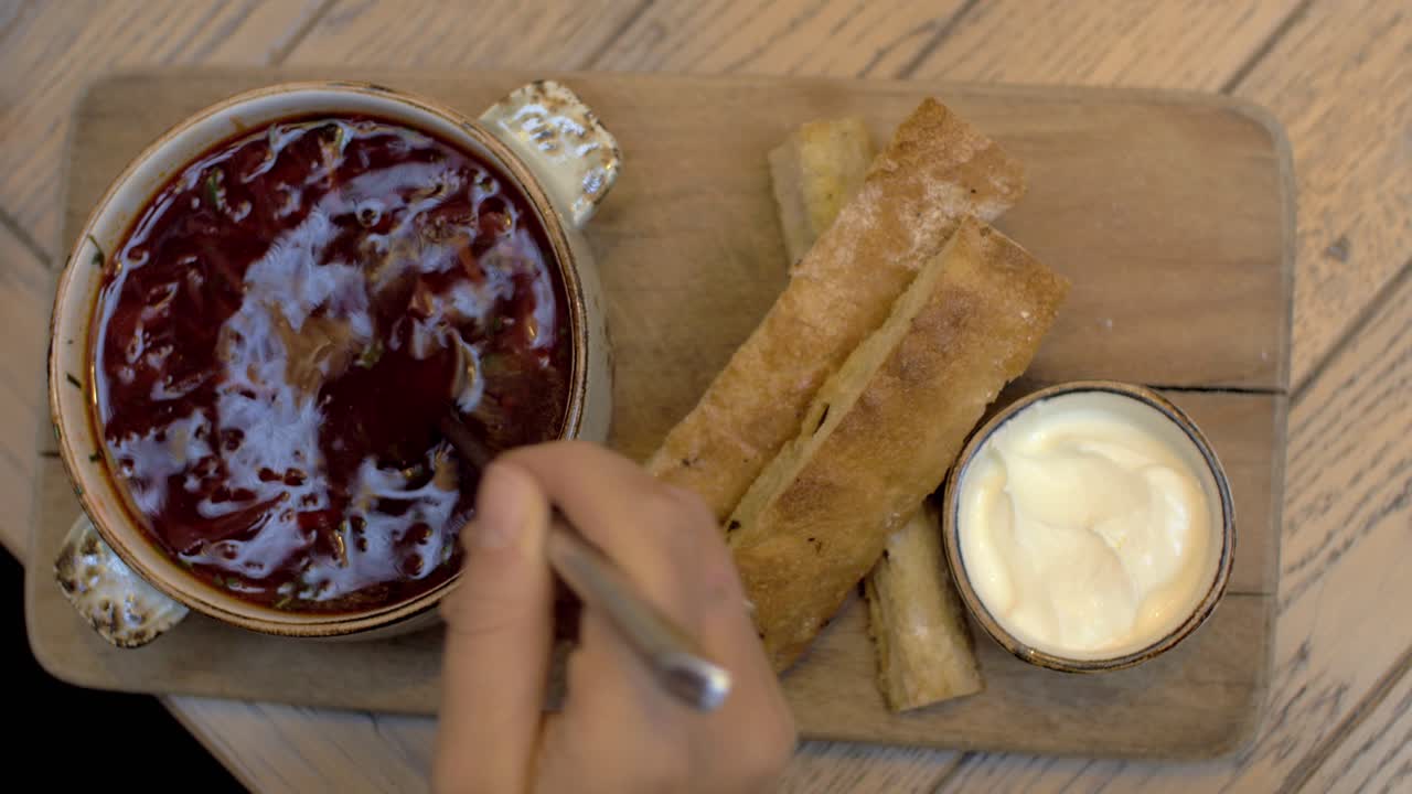 Kobieta je zupę z buraków w restauracji