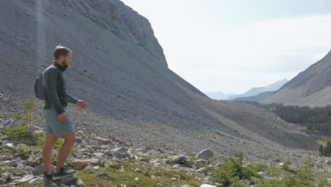 Hiker-walking-down-mountain-sun-flare-Rockies-Kananaskis-Alberta-Canada