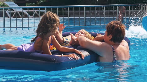 smiling, happy children on a float in a swimming pool.