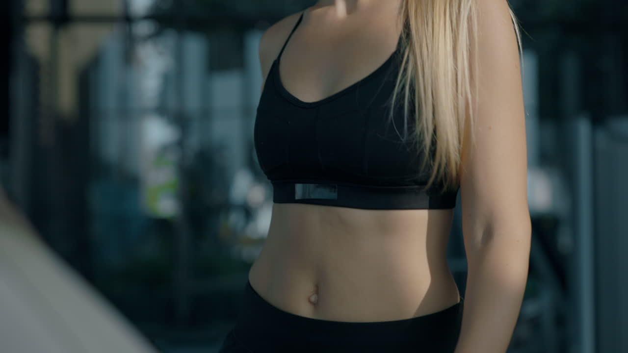 Close-up of a fit woman in athletic wear at the gym
