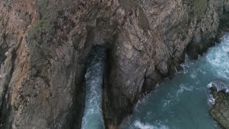 Aerial-tilt-up-of-a-big-rock-formation-in-Zipolite-Oaxaca