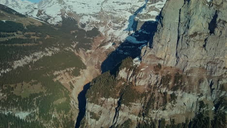 aerial panning up huge cliffs in swiss alps over lauterbrunnen valley