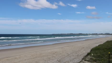 a tranquil beach scene with waves and shifting clouds.