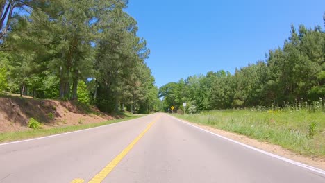 pov conduciendo por una carretera rural a través de una zona boscosa de las zonas rurales de alabama