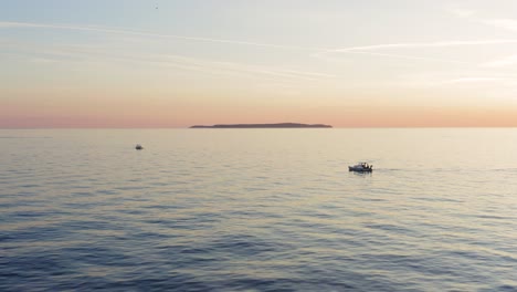 Aerial-view-of-small-boats-in-the-mediterranean-sea-during-a-bautiful-red-sunset