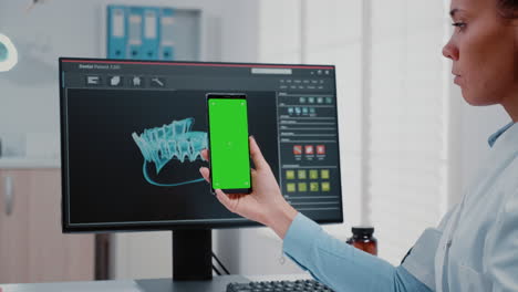 Stomatologe-Hält-Vertikal-Den-Grünen-Bildschirm-Auf-Dem-Mobiltelefon