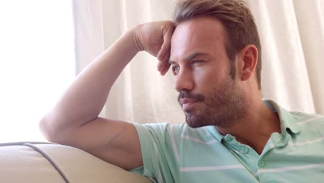 thinking men on sofa with his hand on his forehead