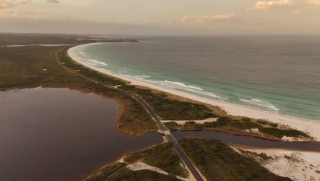 aerial wide shot: bay of fires with lagoon and ocean during sunset time in tasmania, australia