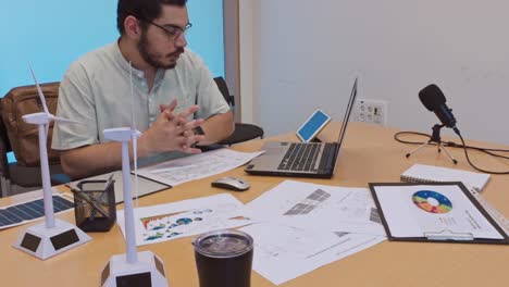 man working on renewable energy project plans in an office