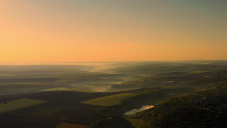 dramatic view of a sunrise over the foggy fields at golden hour in the republic of moldova