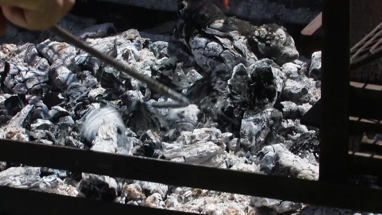 trabajando las brasas en la parrilla