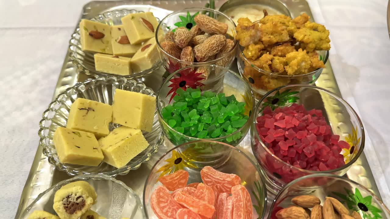 Tracking shot of a varity of indian sweets on the plater,