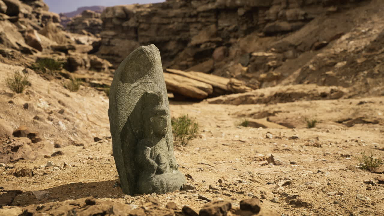 Ancient stone carving in rocky desert landscape under clear sky