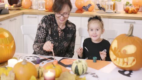 Mother-and-daughter-looking-at-painted-pumpkin