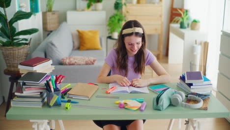 smiling young student doing homework at her desk at home