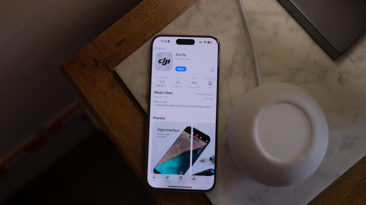Smartphone Screen Displaying DJI Fly Application In App Store. overhead shot
