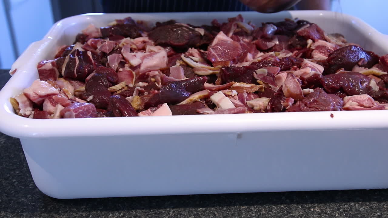 소시지를 만들기 위해 접시 쟁반에 다진 돼지 고기에 곱게 갈은 후추와 물을 추가 - 클로즈업