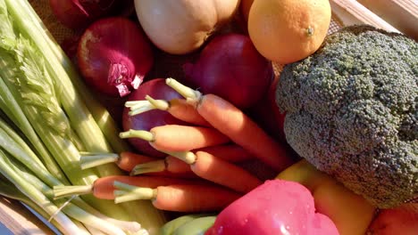 Crate-of-organic-vegetables-on-countertop-in-sunny-kitchen,-slow-motion